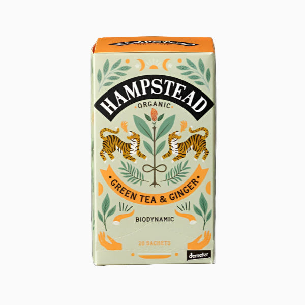 Packaging of Hampstead Organic Green Tea & Ginger. The box is predominantly white with green and orange accents, featuring illustrations of ginger roots and leaves, and text detailing the product and its organic nature.