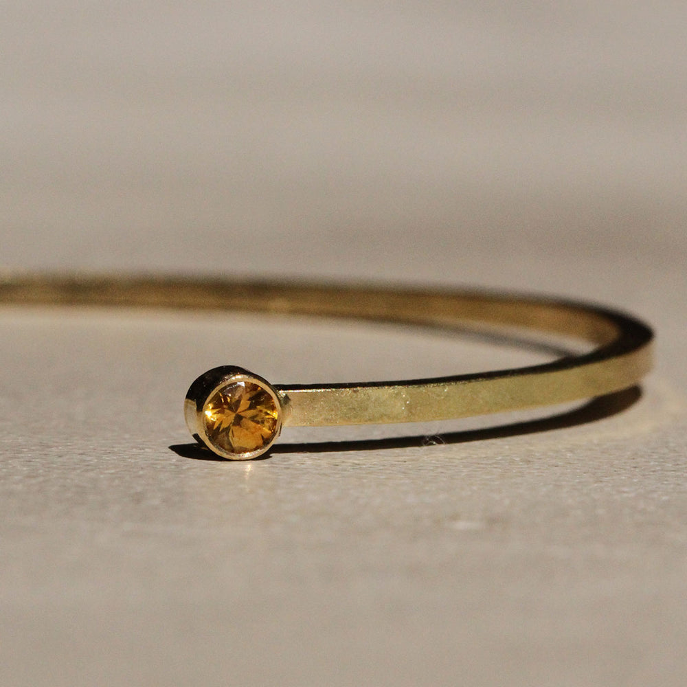 Close up of Sophie Hughes Yellow Montana Sapphire Cuff Bracelet in 18k Yellow Gold featuring two 3mm Dark Yellow Montana Sapphire round gemstones.