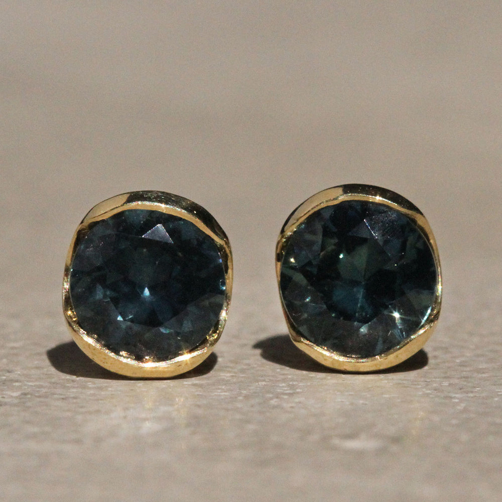 Sophie Hughes Poppy Bezel Montana Sapphire Studs in 18k Yellow Gold featuring a pair of 4.75mm Dark Teal Round Montana Sapphires