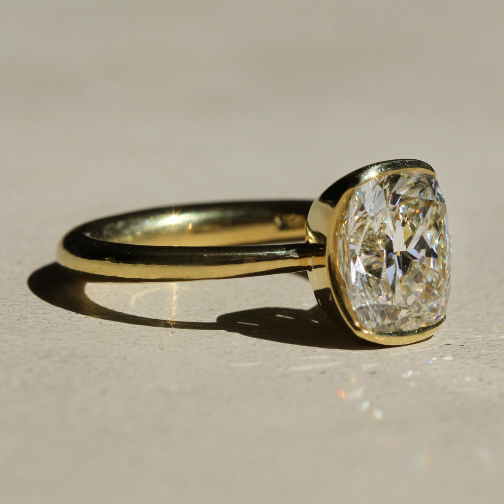 Sophie Hughes Poppy Bezel Solitaire in 18K Yellow Gold featuring a 3-ct Elongated Cushion Cut diamond