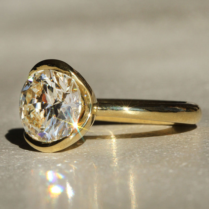 Sophie Hughes Poppy Bezel Solitaire in 18K Yellow Gold featuring a 3-ct Round Brilliant Cut Diamond from a slight angle