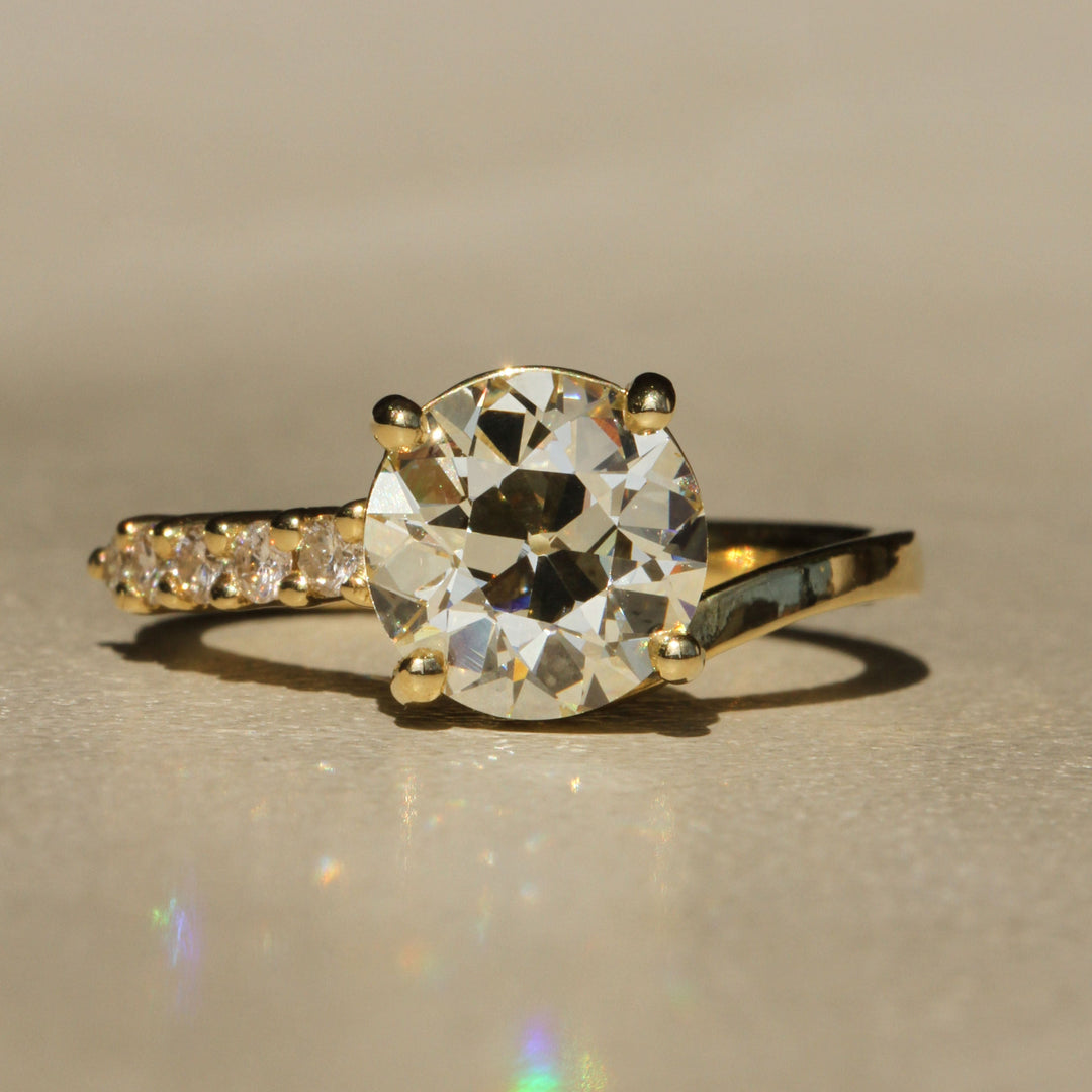 Sophie Hughes Crest Prong Ring in 18K Yellow Gold featuring a 2.5-ct Antique Old European cut diamond with 5 Champagne melee diamonds