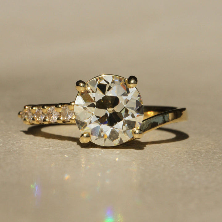 Sophie Hughes Crest Prong Ring in 18K Yellow Gold featuring a 2.5-ct Antique Old European cut diamond with 5 Champagne melee diamonds
