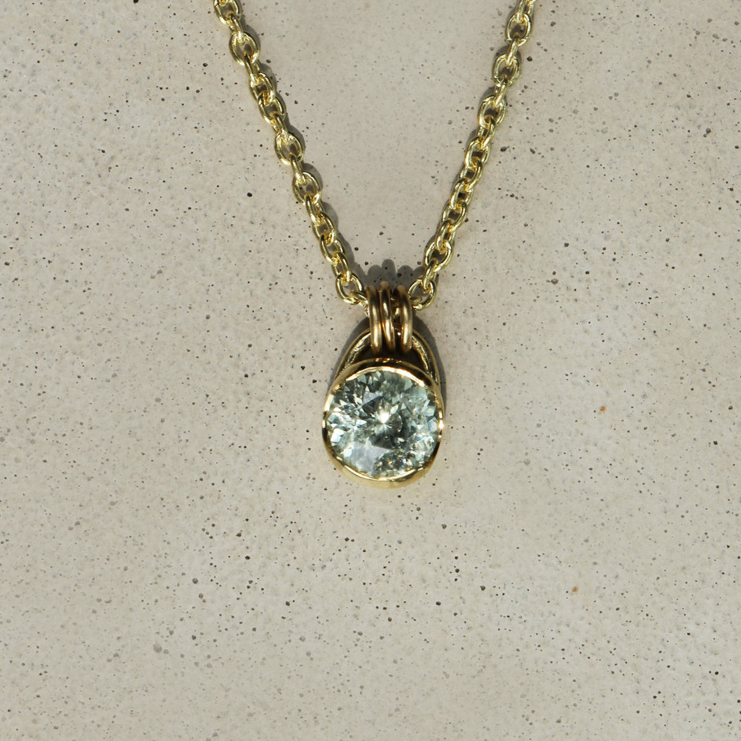 Sophie Hughes Poppy Bezel Montana Sapphire Necklace in 18K Yellow Gold featuring a 1-ct round brilliant light teal seafoam celery Montana Sapphire