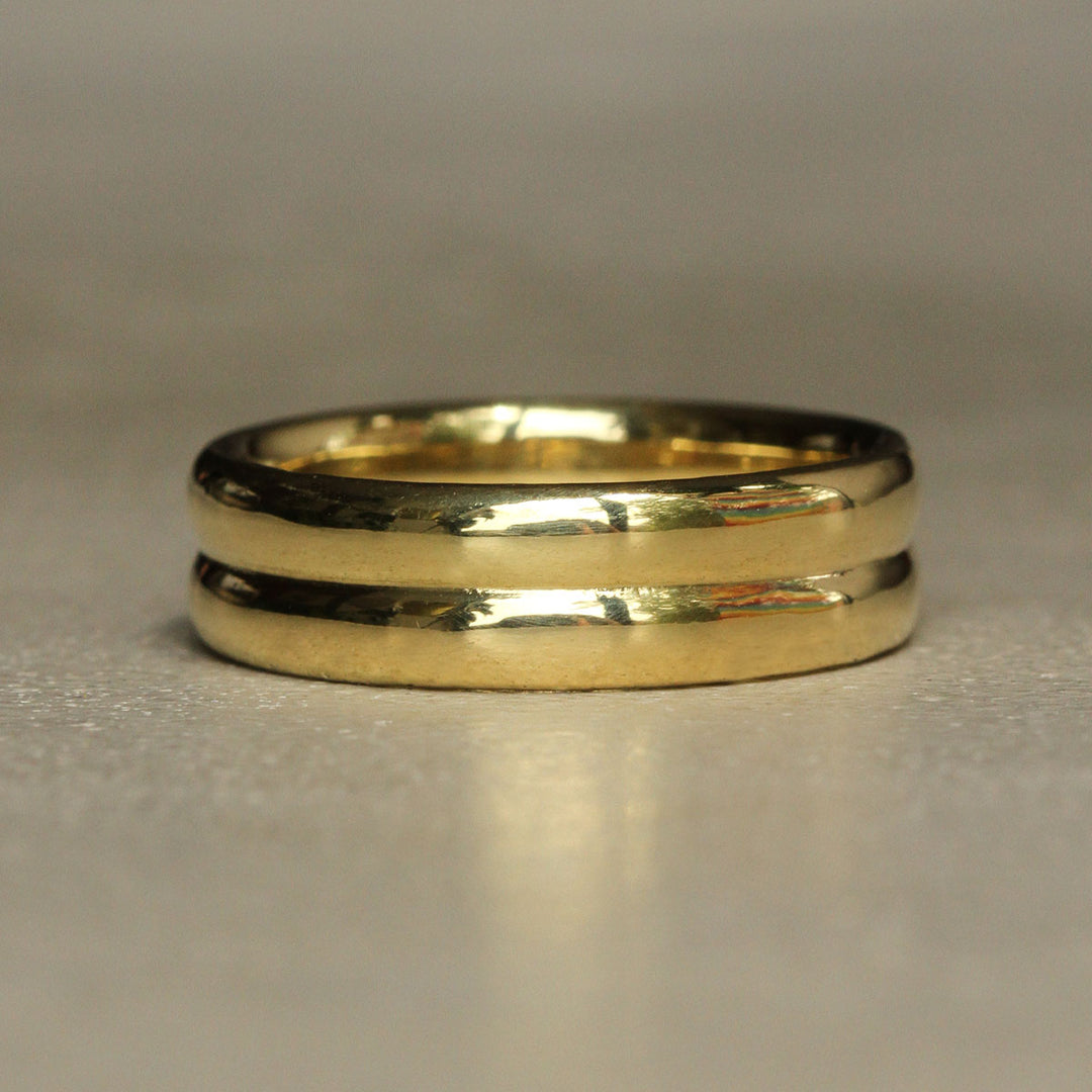 Gold ring with two bands on a gray background