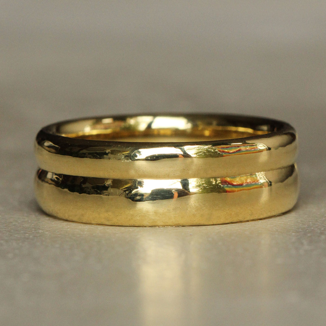 Gold ring with two bands on a gray background
