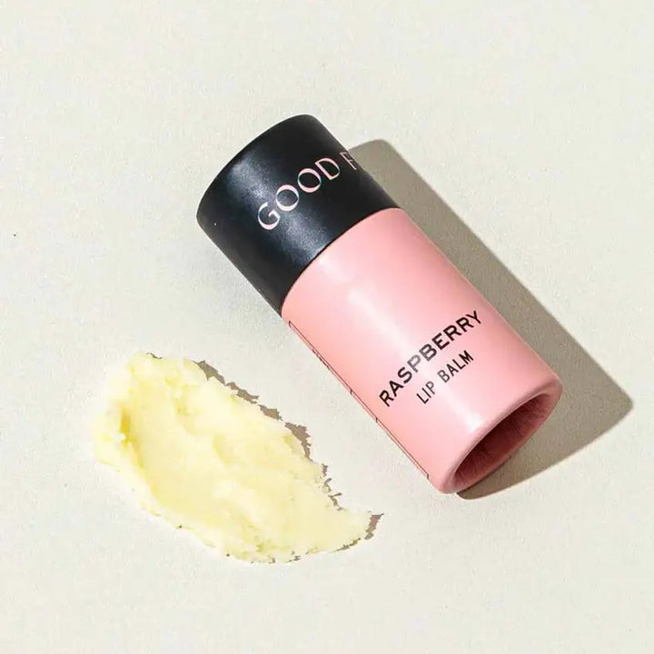 Good Flower Farm Raspberry Lip balm container with a small amount of balm on a white background