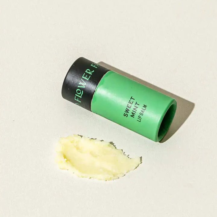 Good Flower Farm Sweet Mint Lip balm container with a small amount of balm on a white background