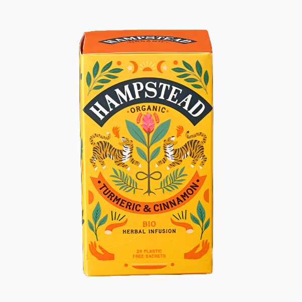 A package of Hampstead Organic Turmeric & Cinnamon Herbal Infusion tea. The packaging is colorful with illustrations of turmeric and cinnamon plants and the box is predominantly yellow.