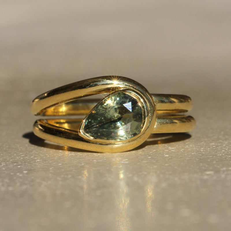 Sophie Hughes Poppy Bezel Loop Solitaire in 18K Yellow Gold featuring a 1-ct Teal Blue-Green Pear Cut Montana Sapphire