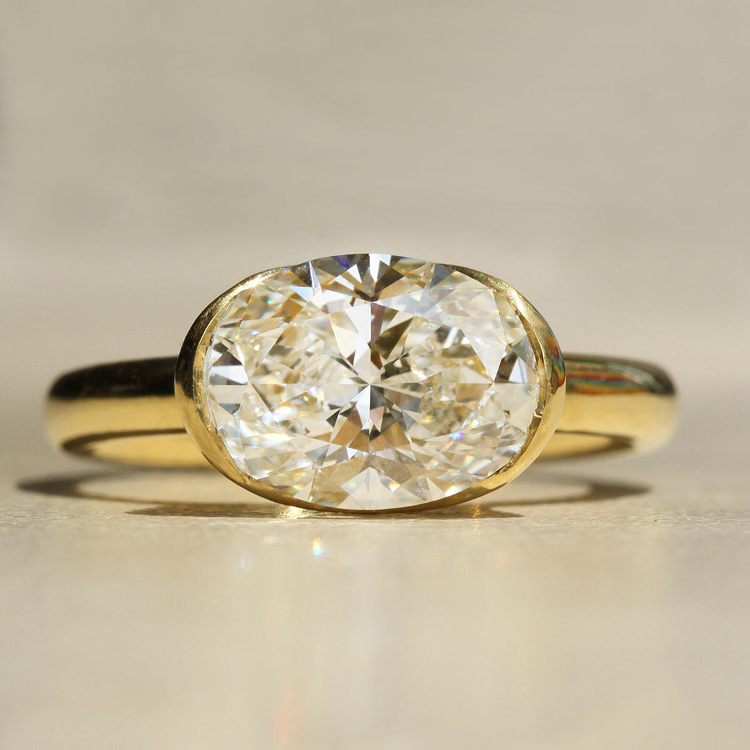 Gold ring with a large diamond on a neutral background