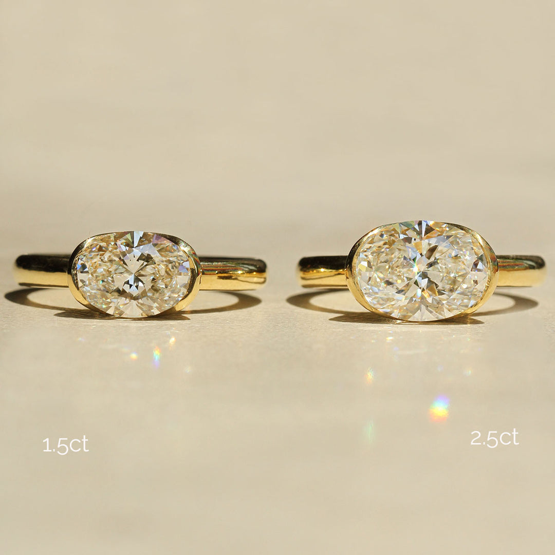 Two gold rings with diamond stones on a beige background