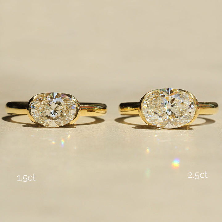 Two gold rings with diamond stones on a beige background