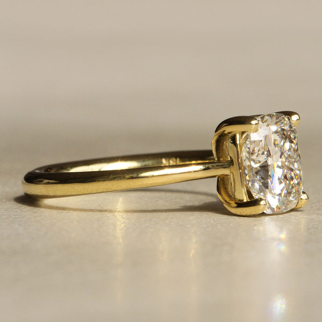 Sophie Hughes Iris Prong Solitaire in 18K Yellow Gold featuring a 2.5-carat Cushion Cut Diamond from a slight angle