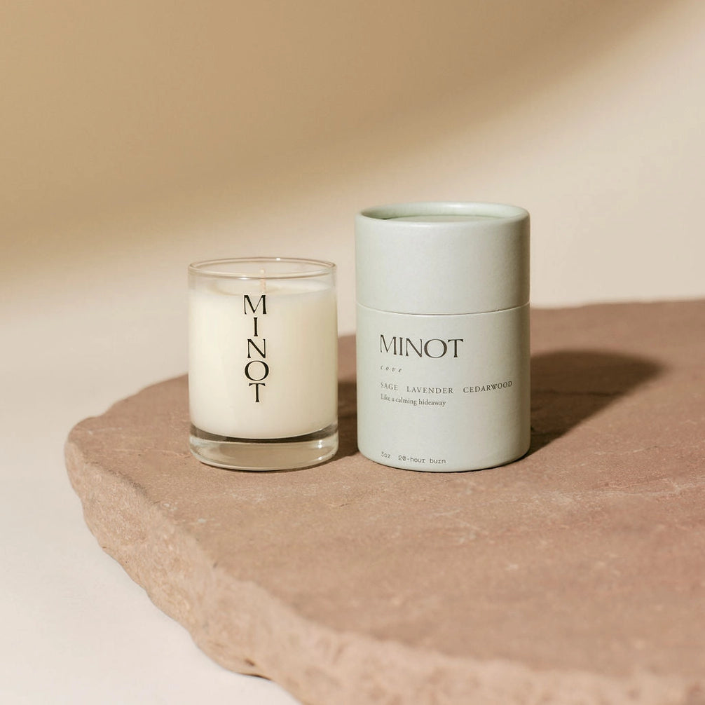 Candle and its packaging with 'MINOT' branding on a beige background