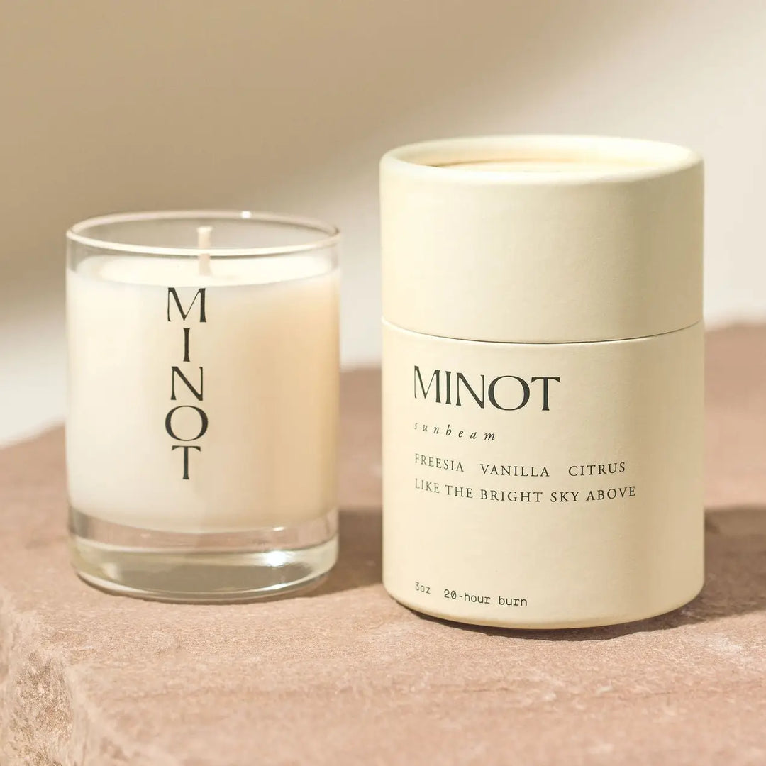 MINOT candle and container on a beige surface