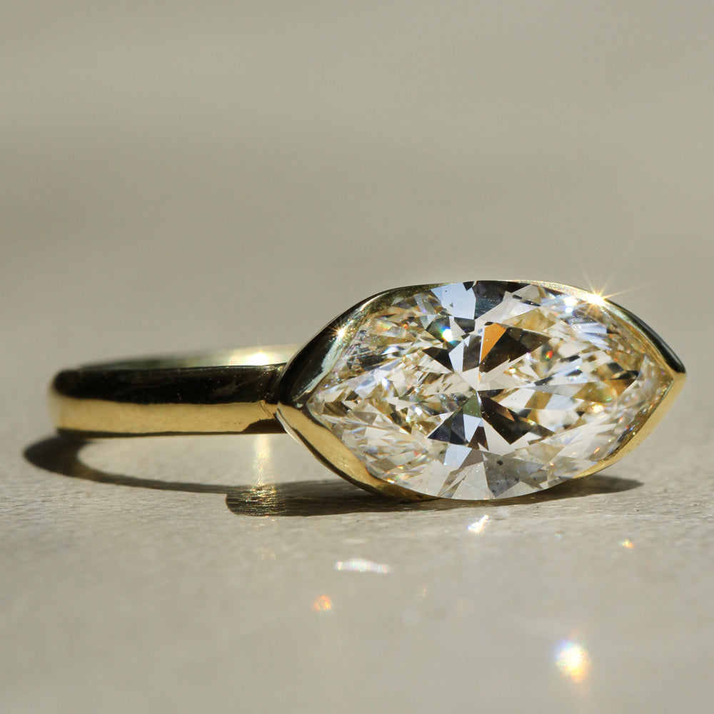 Sophie Hughes Poppy Bezel East-West Solitaire in 18K Yellow Gold featuring a 3-carat Marquise Cut Diamond from a slight angle