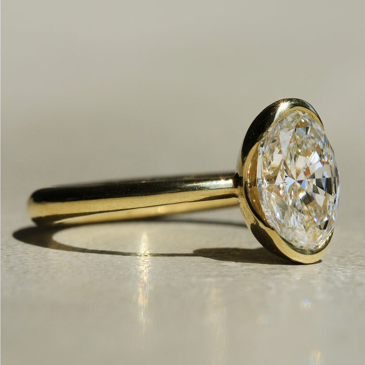 Sophie Hughes Poppy Bezel North-South Solitaire in 18K Yellow Gold featuring a 2-carat Oval Cut Diamond from a slight angle