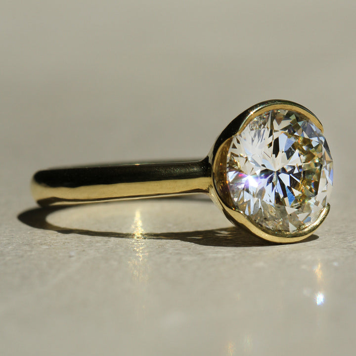 Sophie Hughes Poppy Bezel Lofted Solitaire in 18K Yellow Gold featuring a 3-carat Round Brilliant Cut Diamond from a slight angle