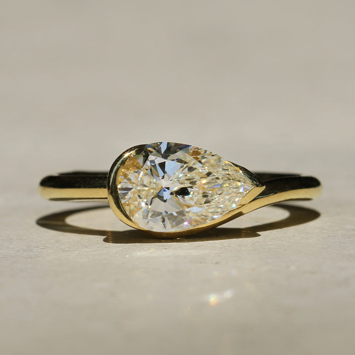 Sophie Hughes Poppy Bezel Wave II Solitaire in 18K Yellow Gold, featuring a 1.5-ct Pear cut diamond