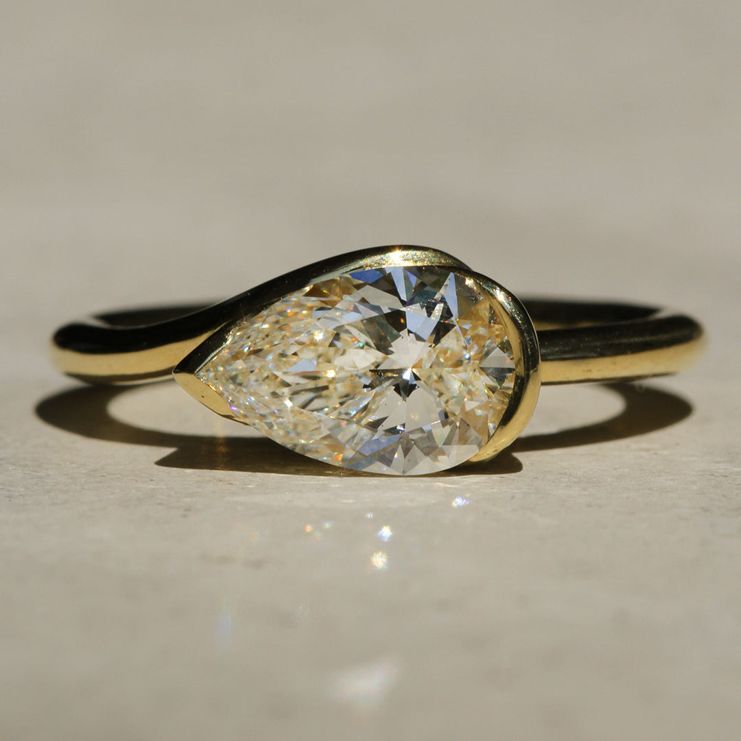 Sophie Hughes Poppy Bezel Wave II Solitaire in 18K Yellow Gold, featuring a 1.5-ct Pear cut diamond