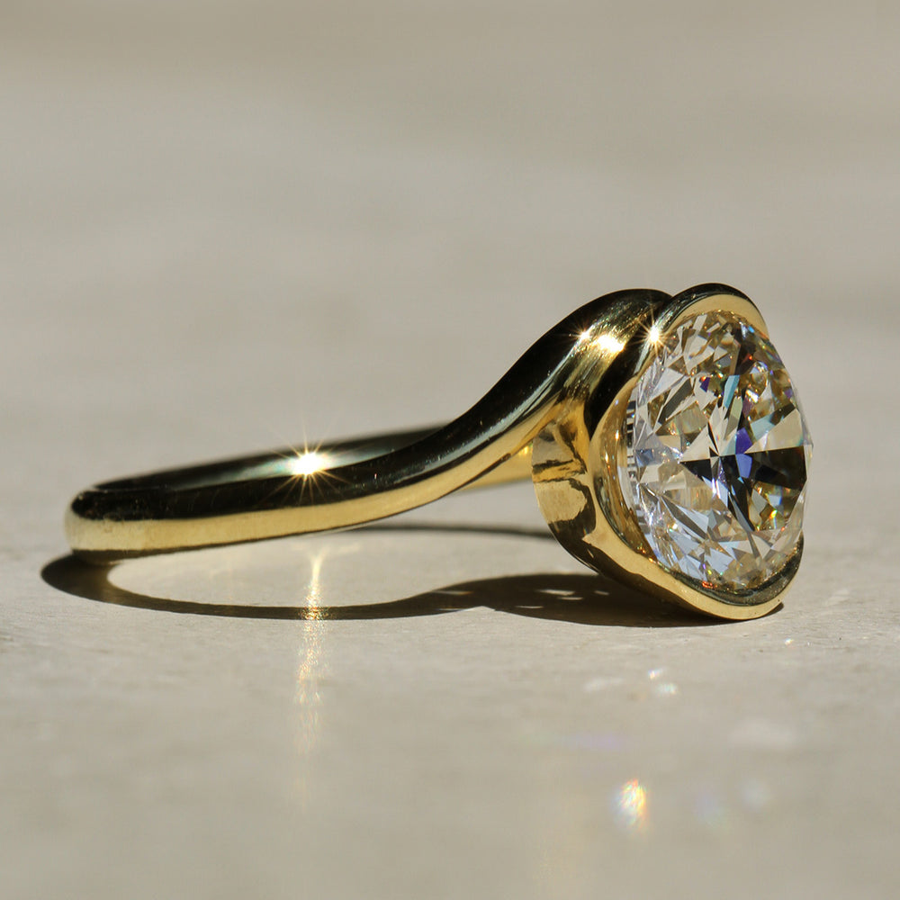 Sophie Hughes Poppy Bezel Wave II Solitaire featuring 18K Yellow Gold and a 2-carat Round Brilliant Diamond from a side angle