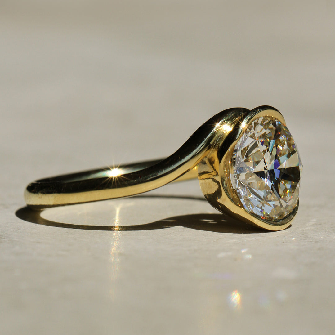 Sophie Hughes Poppy Bezel Wave II Solitaire featuring 18K Yellow Gold and a 2-carat Round Brilliant Diamond from a side angle