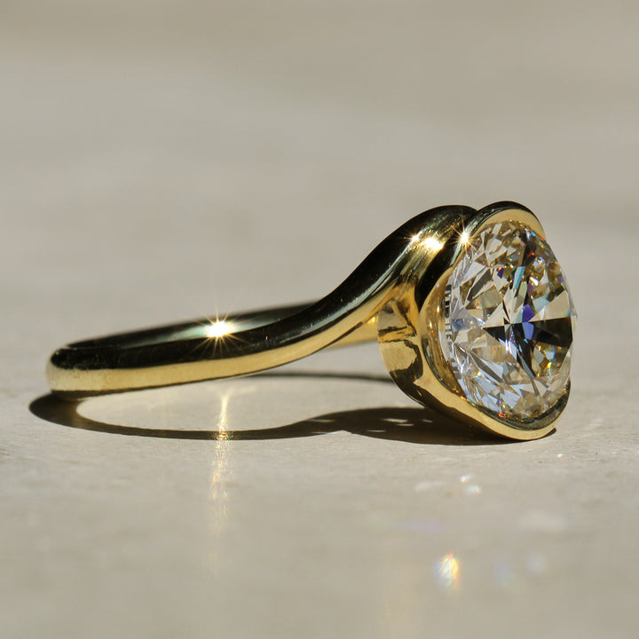 Sophie Hughes Poppy Bezel Wave II Solitaire featuring 18K Yellow Gold and a 2-carat Round Brilliant Diamond from a side angle