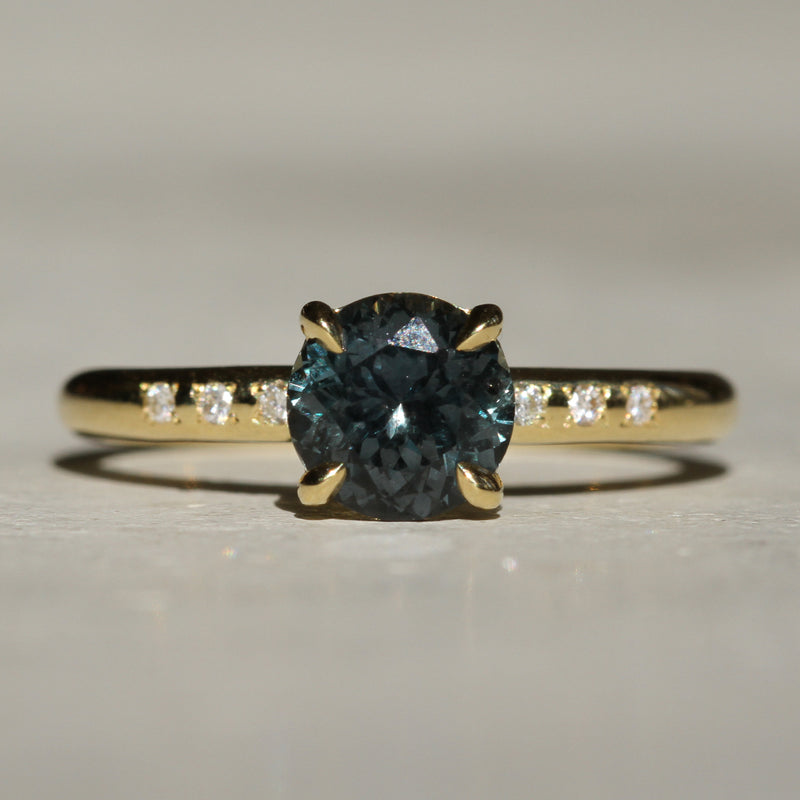 Sophie Hughes Sweetheart Prong Solitaire in 18K Yellow Gold featuring a Round Brilliant Montana Sapphire and accent melee diamonds on the band